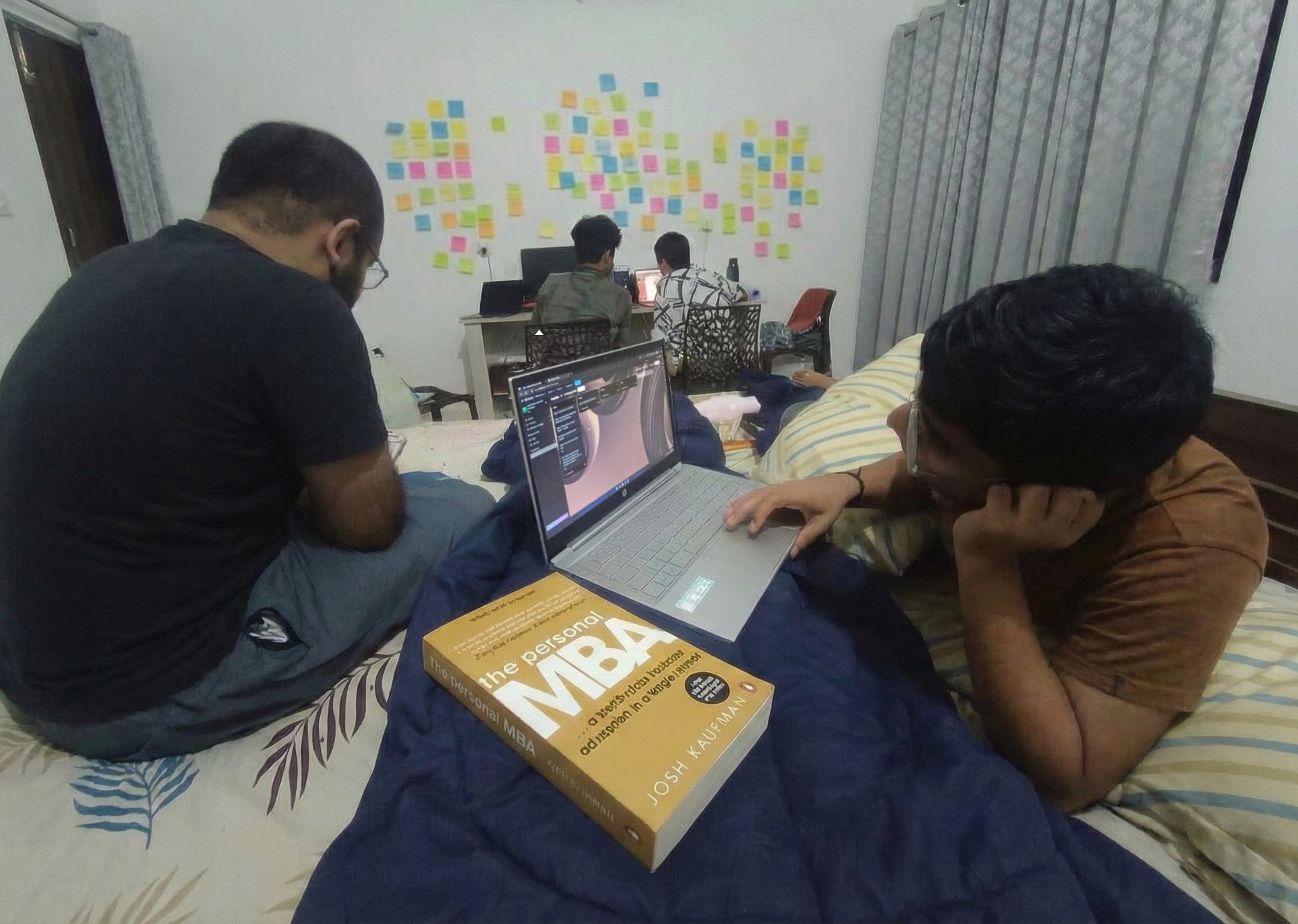 The Personal MBA book and team working on laptops